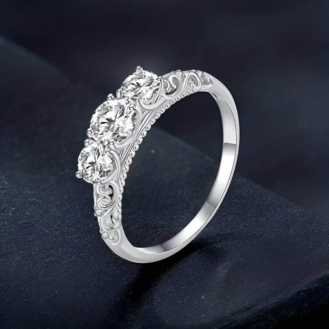 Bague trilogie triple diamants debout vue de côté sur une surface noire.