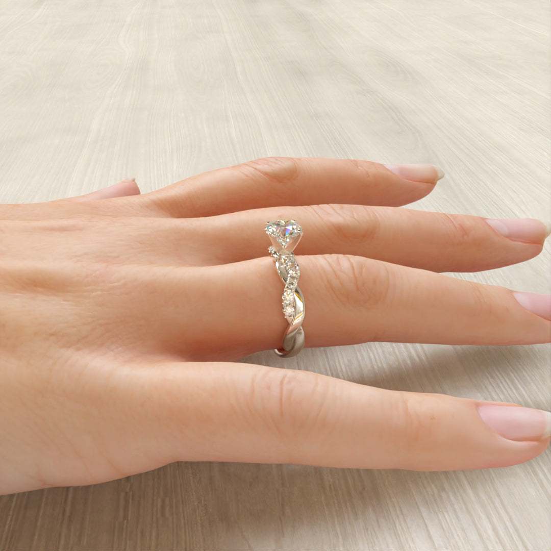 Vue latérale de la bague de fiançailles en argent tressée sur le doigt d'une femme, avec zircon cubique et plaquage or blanc 18K - La Petite Rebelle.
