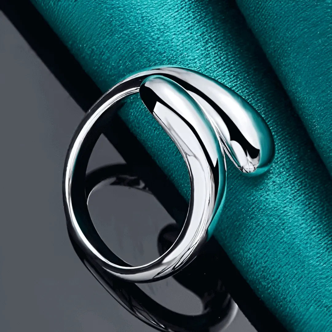 Bague goutte d'eau en acier inoxydable et or blanc posée.