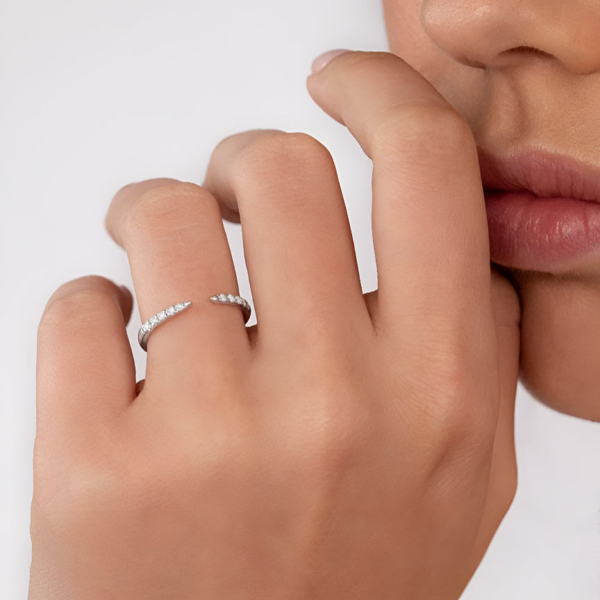 Bague ouverte en argent sterling 925 portée à la main d'une femme, illuminée par des diamants en zircons et un plaquage or blanc 18K, ajoutant une élégance subtile à toute occasion - La Petite Rebelle