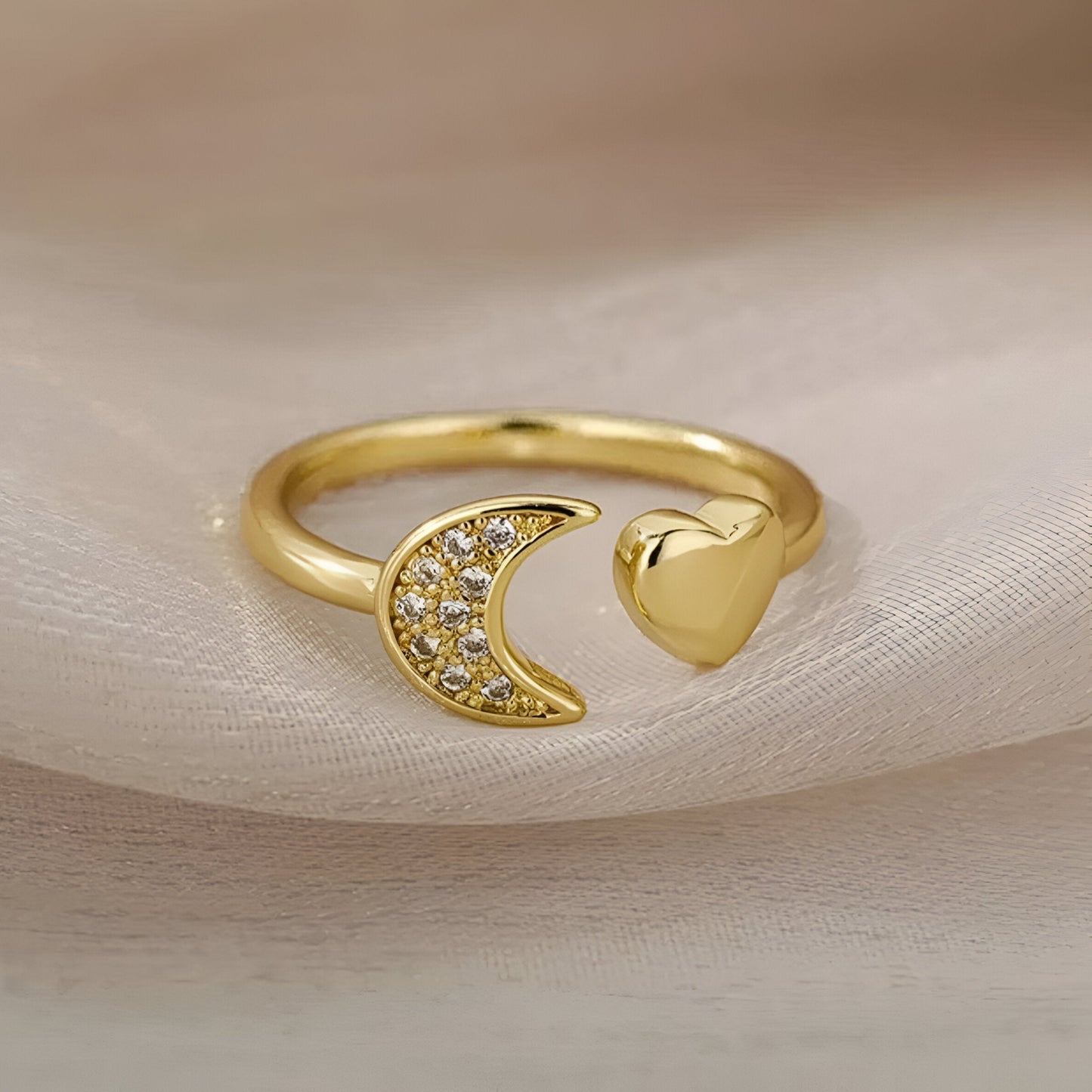 Vue de face de la bague ouverte en or cœur céleste et croissant doré sur tissu soyeux – éclat des zircons et plaquage or 18K
