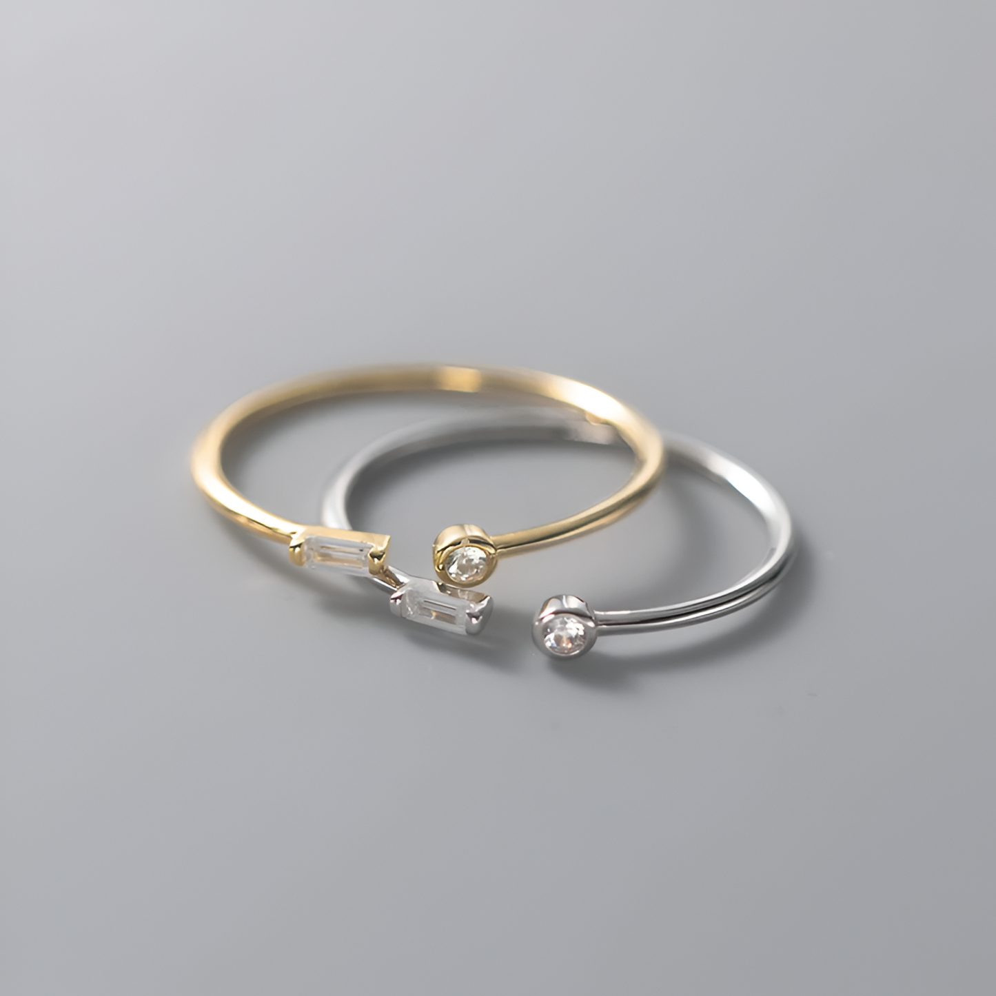 Bague ouverte en or duo d'éclats, empilée sur un fond gris or et or blanc. Une alliance parfaite de l'argent sterling 925 et zircons étincelants, plaquée or 18K.