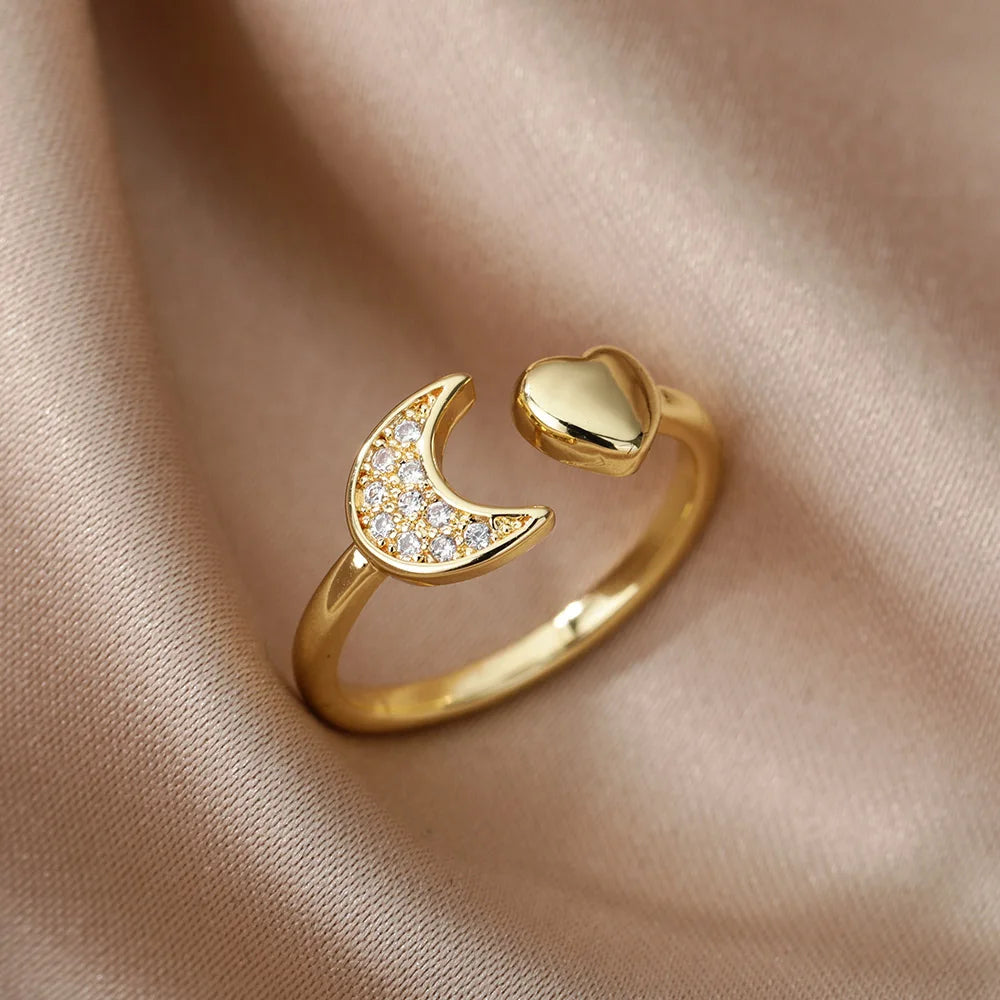 Bague ouverte en or 18K en forme de cœur et croissant doré avec zircons, élégamment posée sur un drap – bijou chic et symbolique