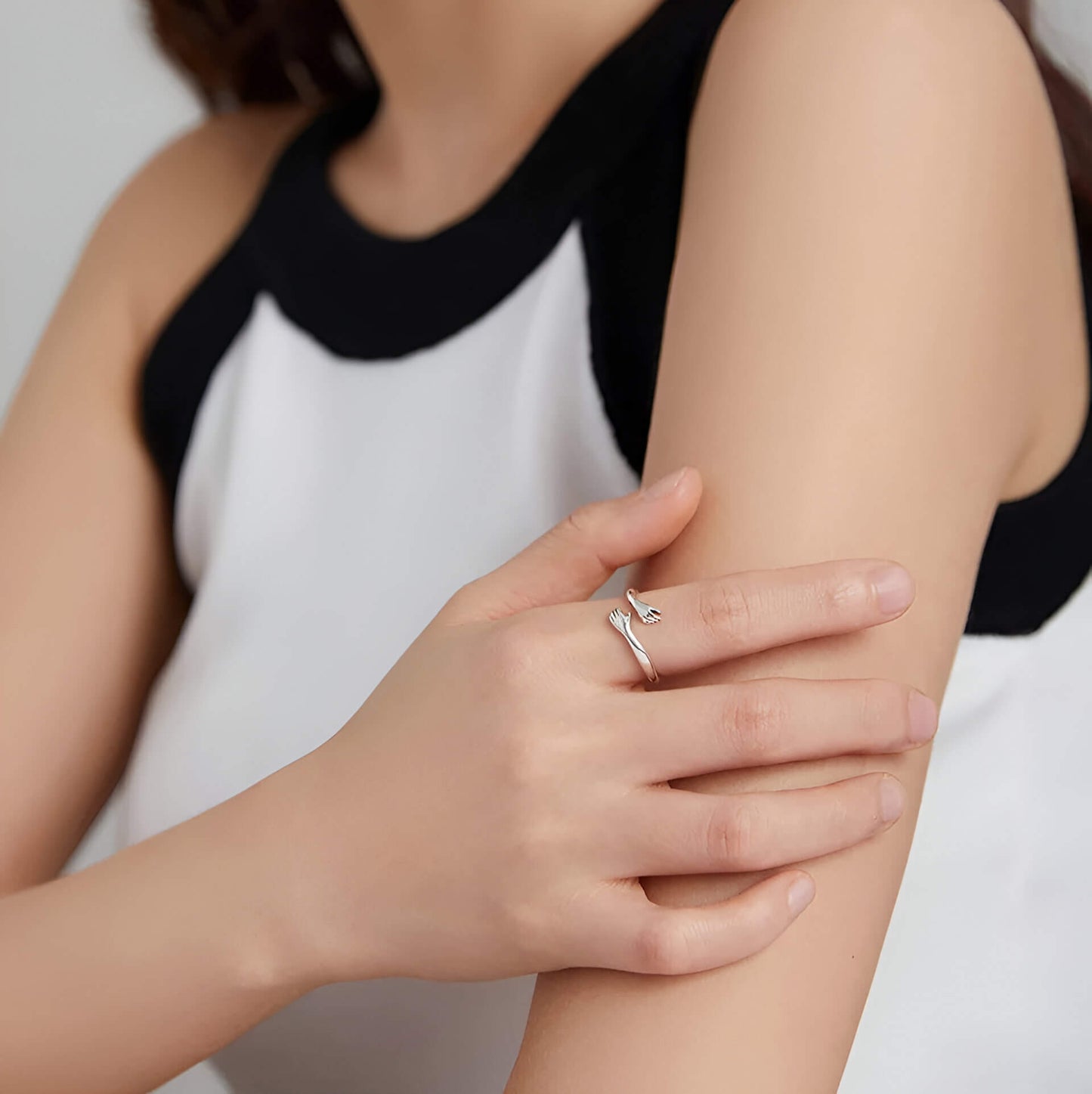 Bague fantaisie ouverte enlacement en argent 925 et or blanc portée à l'index d'une femme.