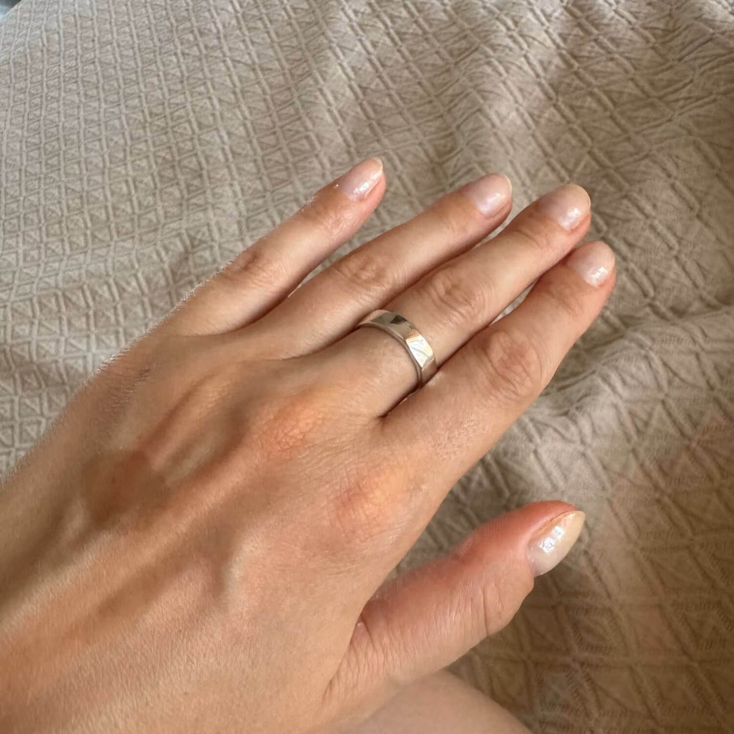 Bague ouverte martelée en argent 925 rhodié portée qu doigt d'une femme.