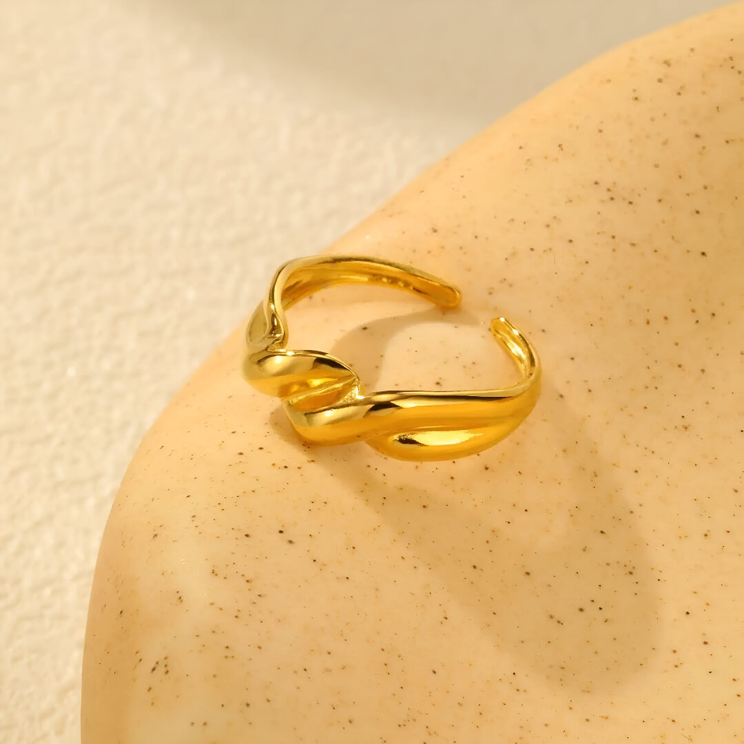 Bague ouverte torsadée en acier inoxydable et or jaune vue de côté.