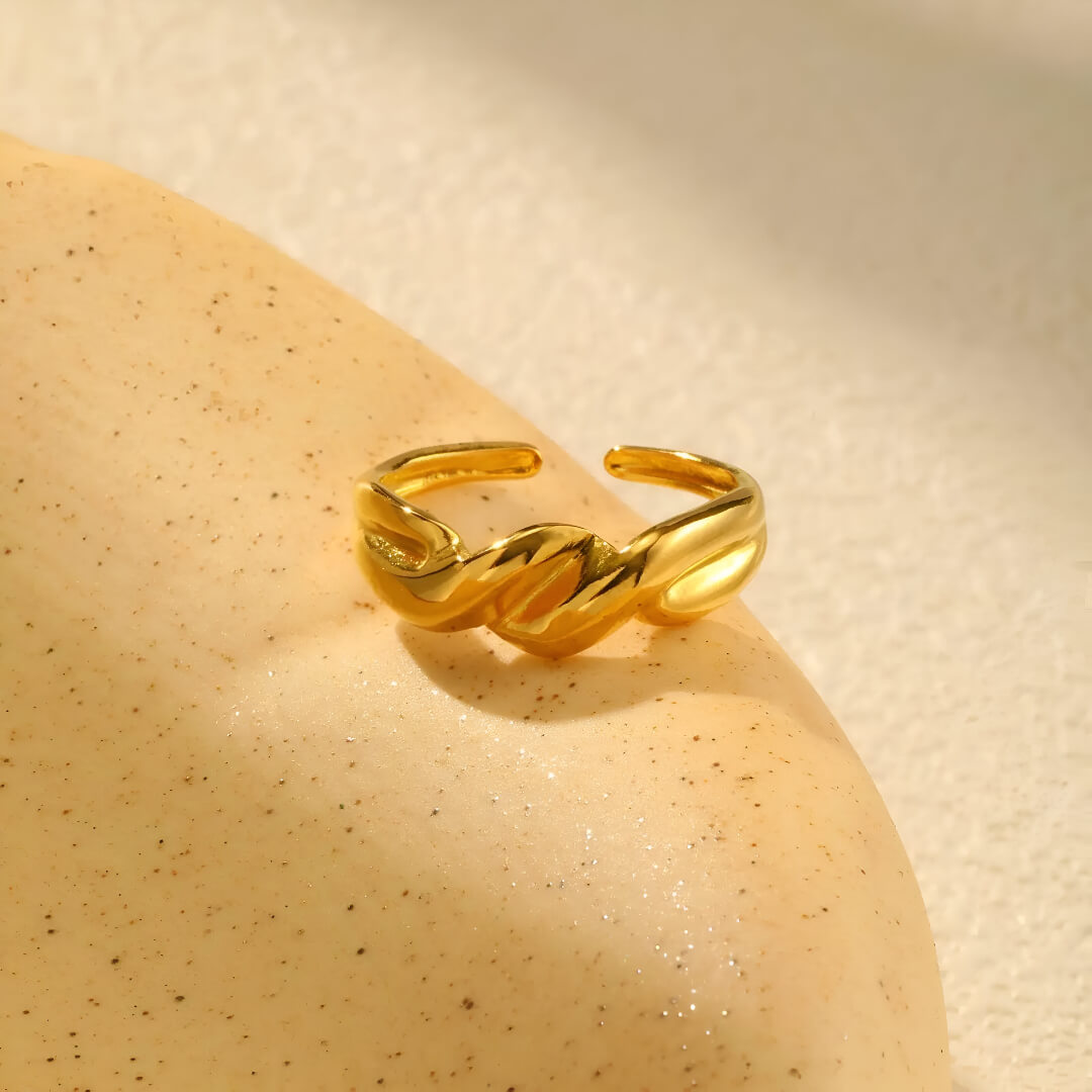 Bague ouverte torsadée en acier inoxydable et or jaune vue de face.