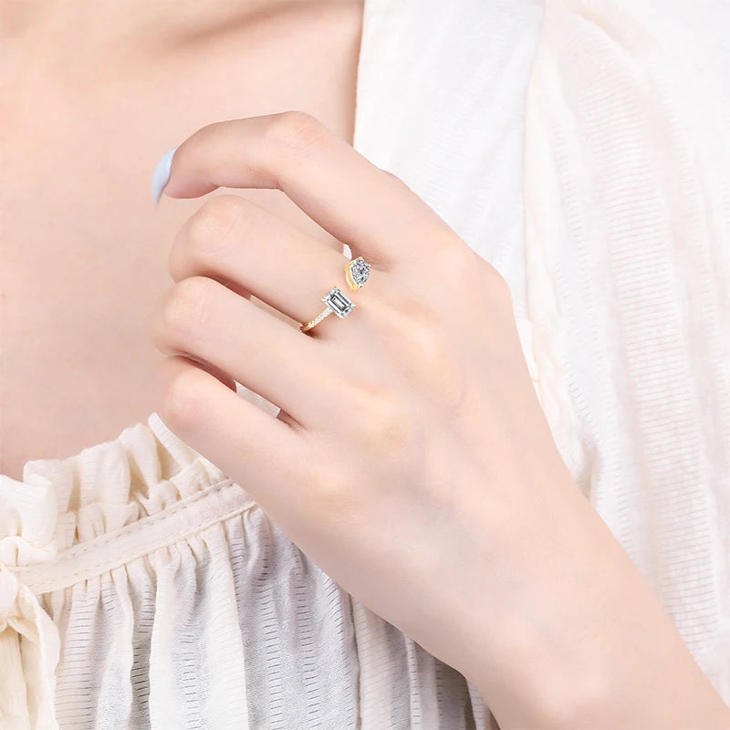 Bague ouverte en or jaune et diamants naturels portée au doigt d'une femme vue de loin.