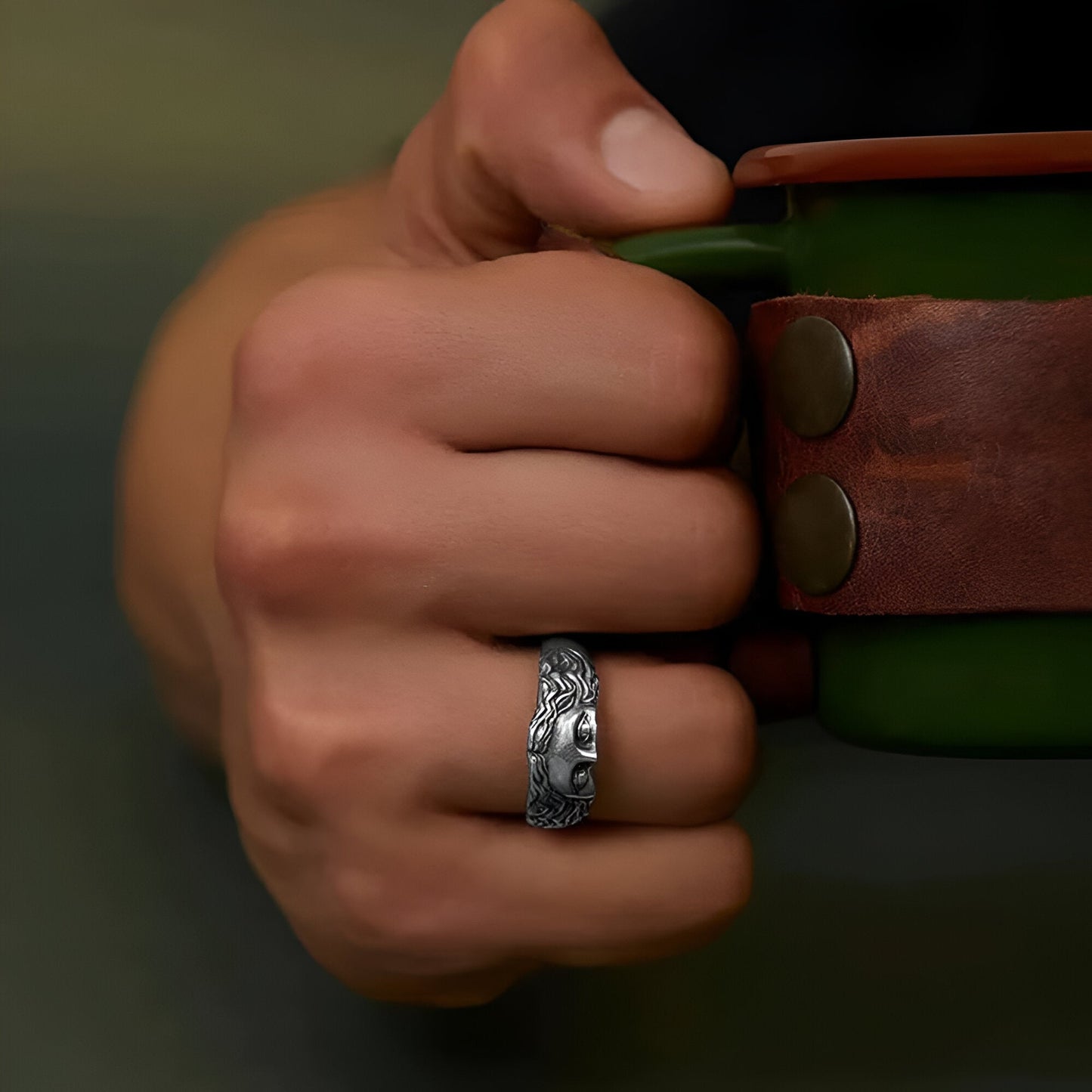 Bague rétro demi-visage de Vénus sculpté en acier inoxydable 316L portée au doigt d'un homme vue de proche.