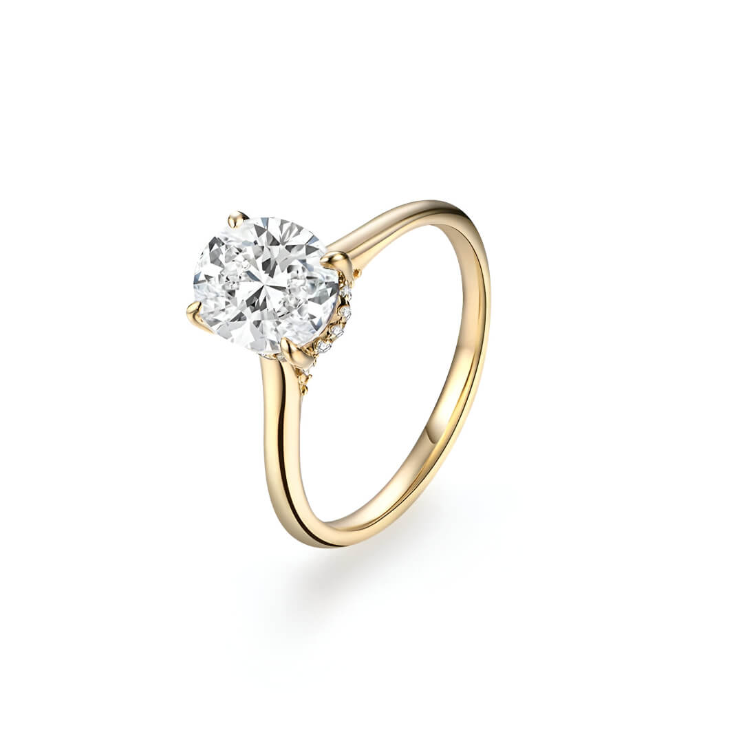 Bague solitaire en or jaune et diamant synthétique sur fond blanc.