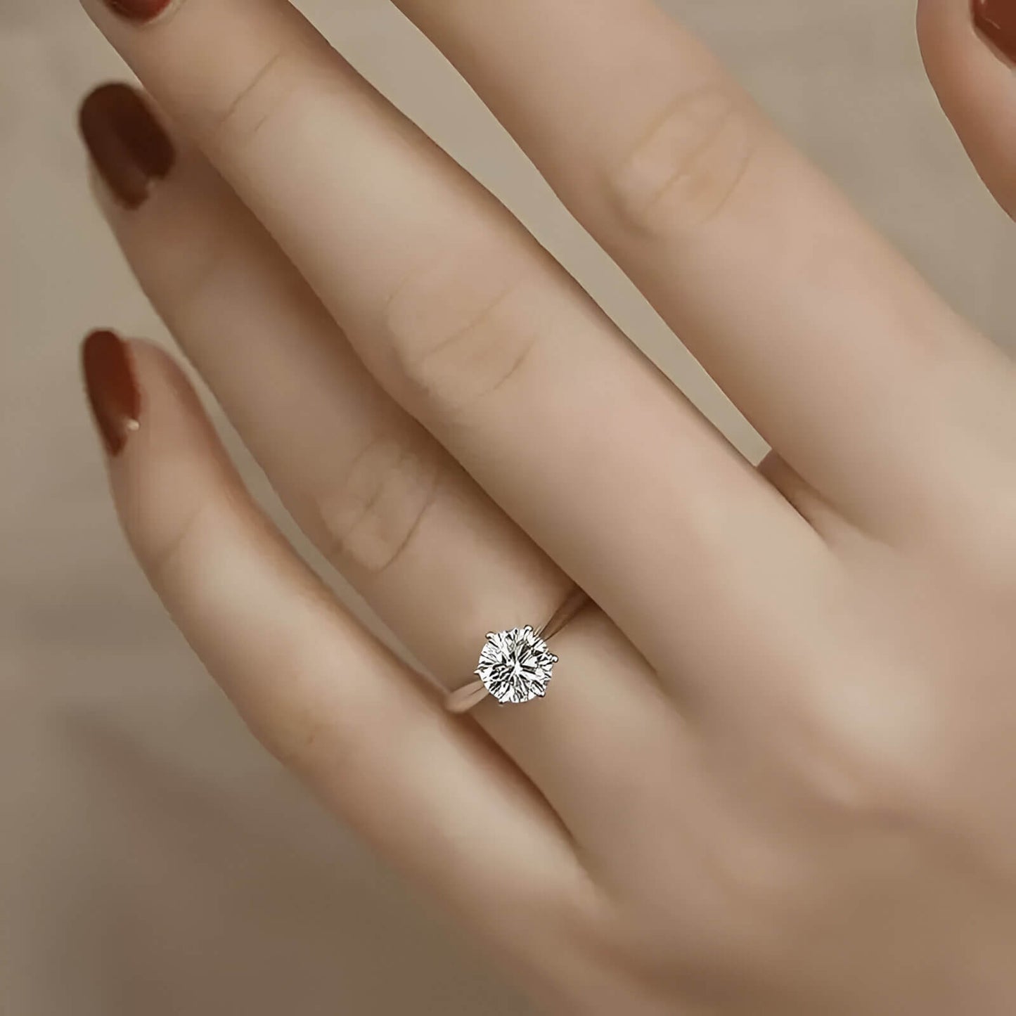 Bague solitaire en or blanc et oxyde de zirconium portée au doigt d'une femme.