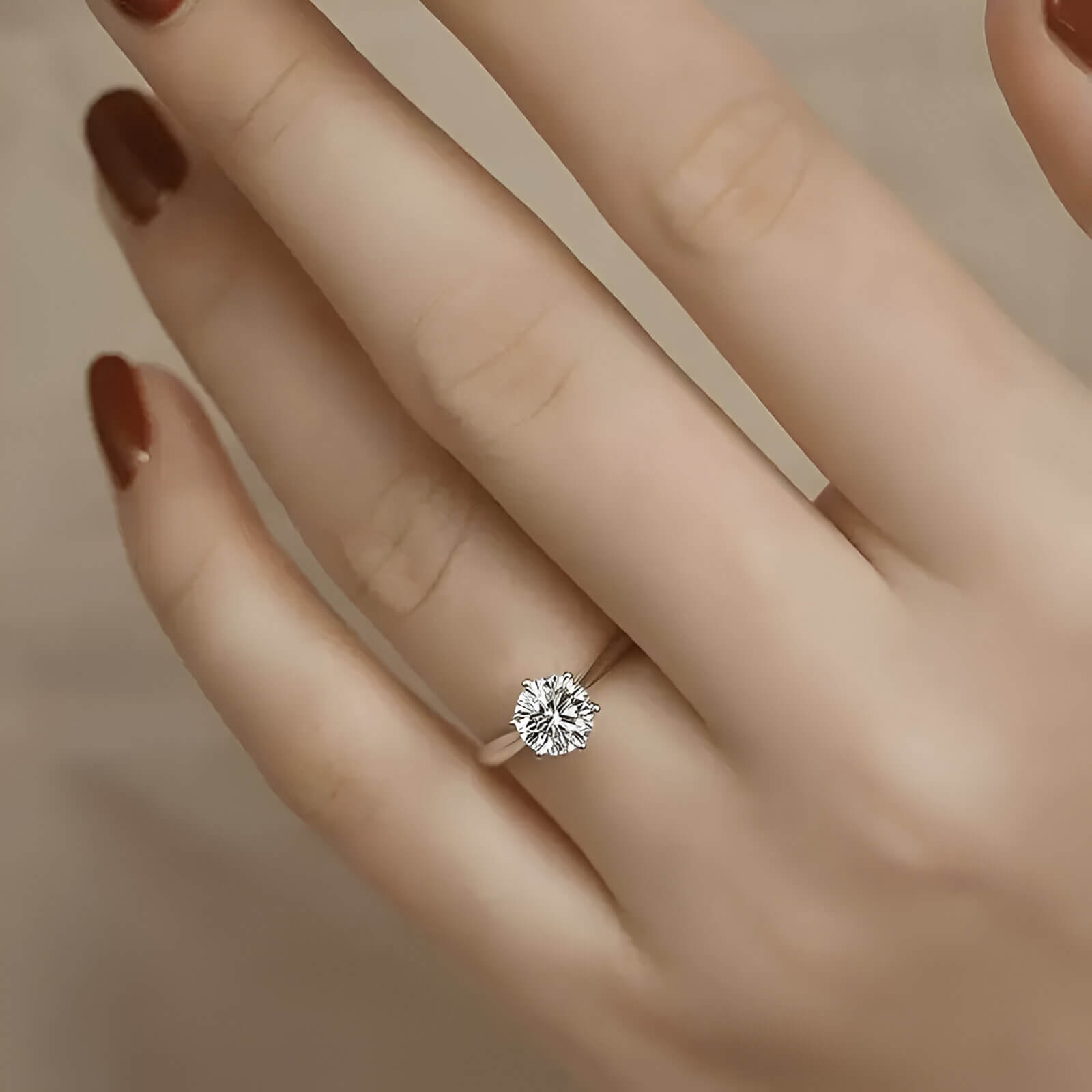 Bague solitaire en or blanc et oxyde de zirconium portée au doigt d'une femme.