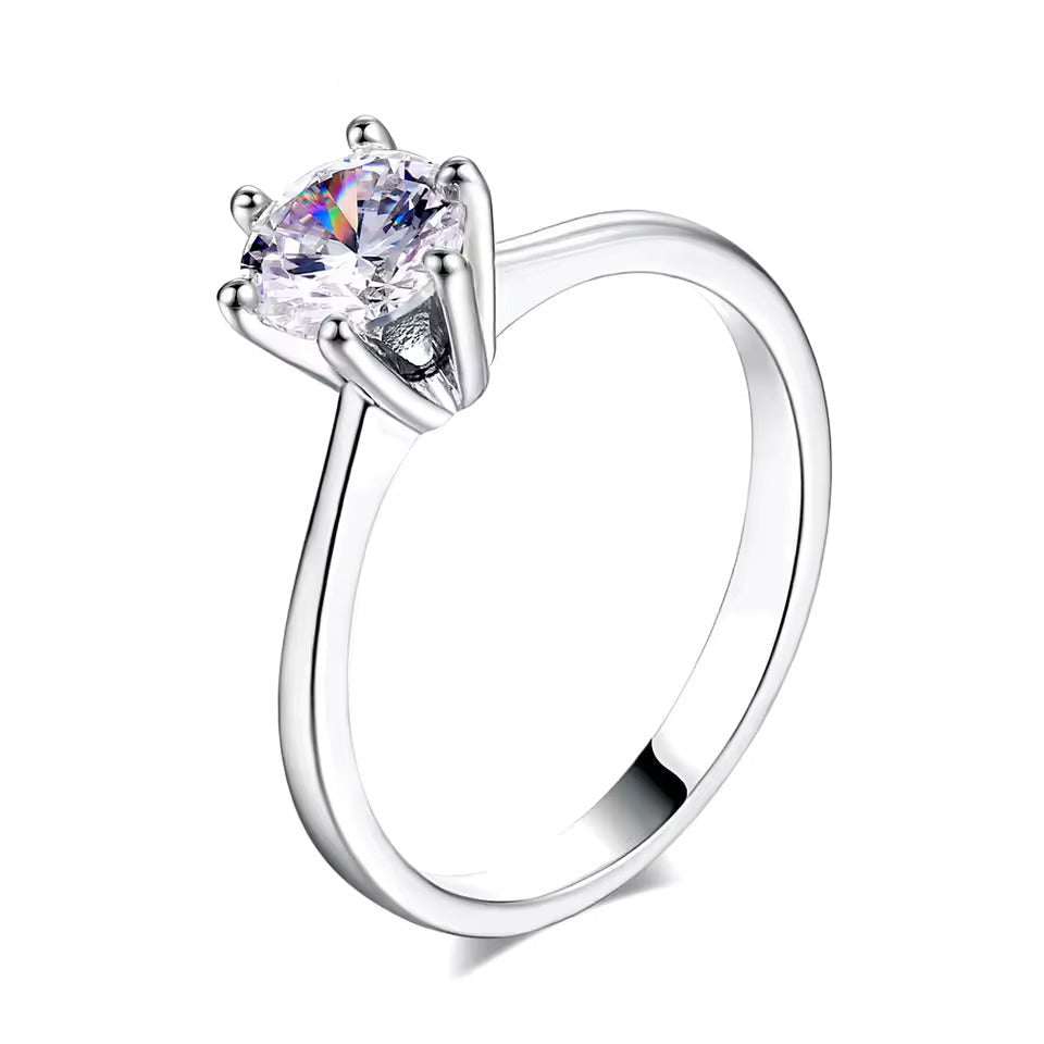 Bague solitaire en or blanc et oxyde de zirconium sur fond blanc.