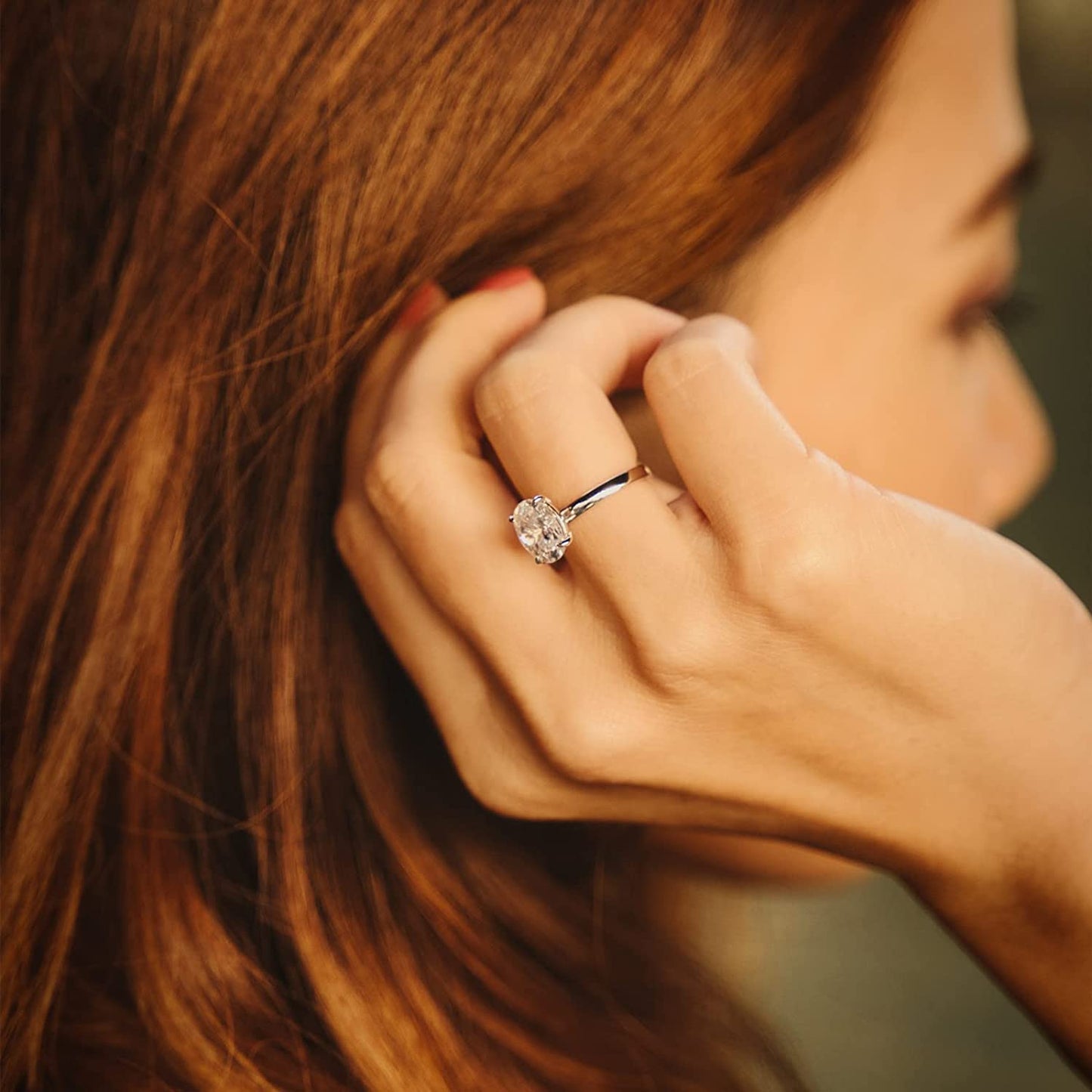 Bague solitaire en or blanc et diamant naturel portée au doigt d'une femme.