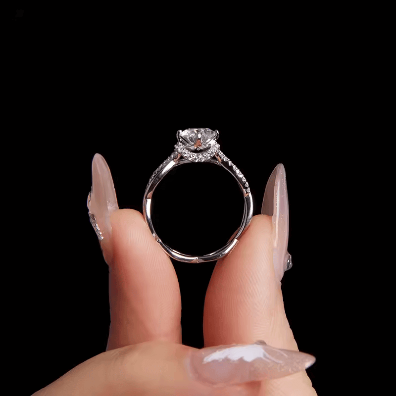 Bague solitaire courbée en or blanc et diamants synthétiques vue latérale sur un doigt.