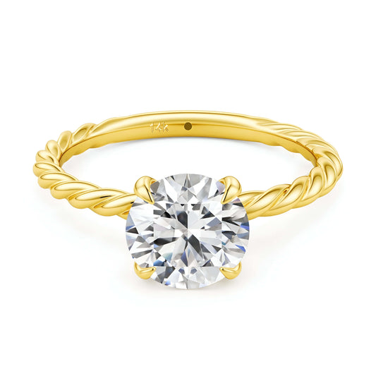 Bague solitaire ondulée en or jaune et diamant synthétique sur fond blanc.