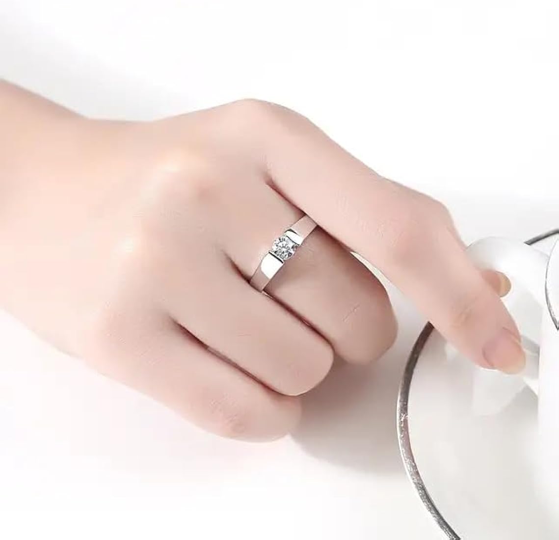 Bague solitaire serti tension en argent 925 plaqué platine et cristal naturel portée au doigt d'une femme.