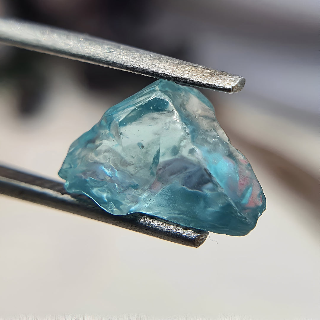 Diamant en zircon bleu pur tenu dans une pince de joaillerie, éclat intense et couleur vibrante, pierre précieuse idéale pour des créations de luxe pour femme - La Petite Rebelle