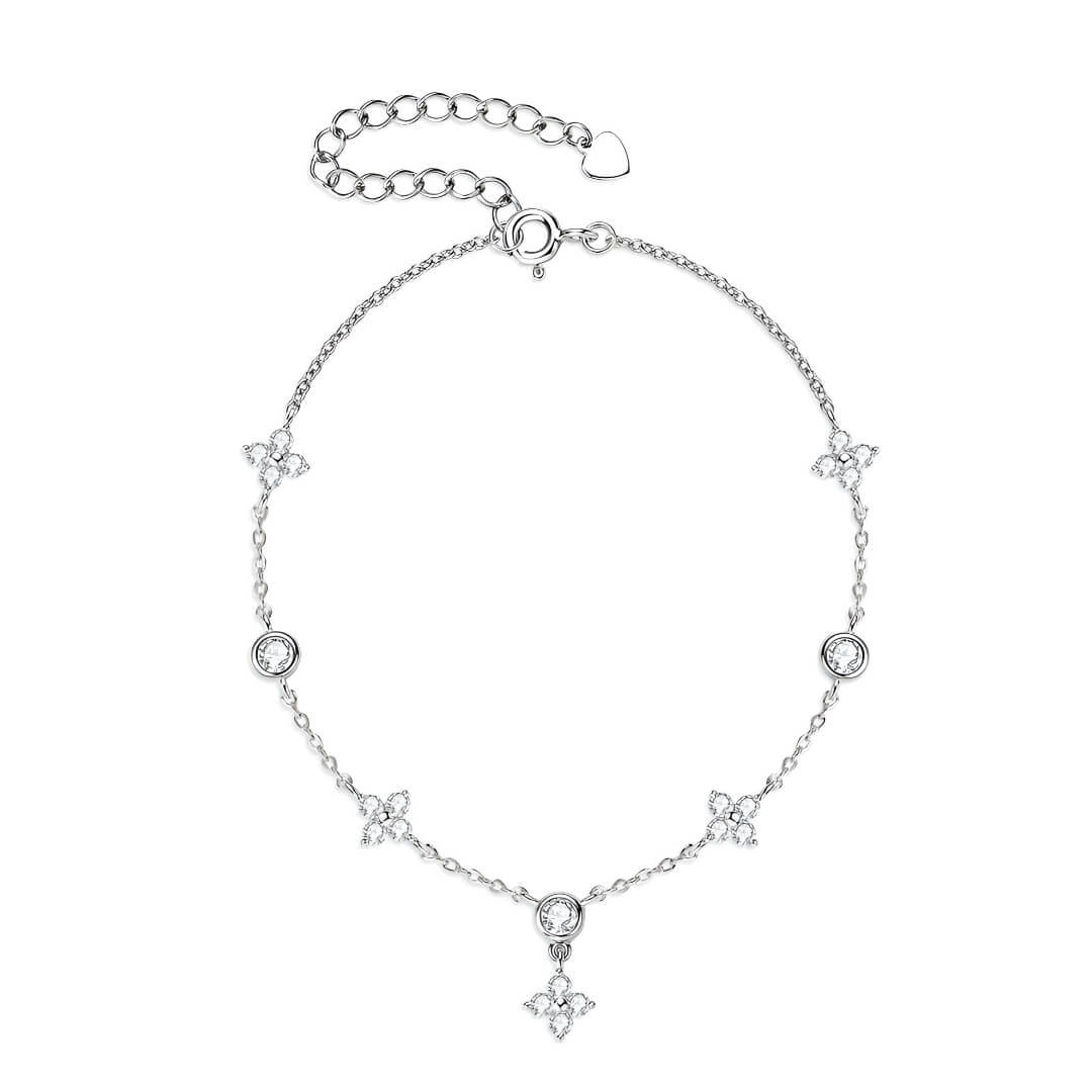 Bracelet à breloques en or blanc et diamants synthétiques sur fond blanc.