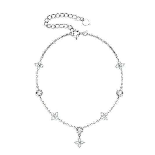 Bracelet à breloques en or blanc et diamants synthétiques sur fond blanc.