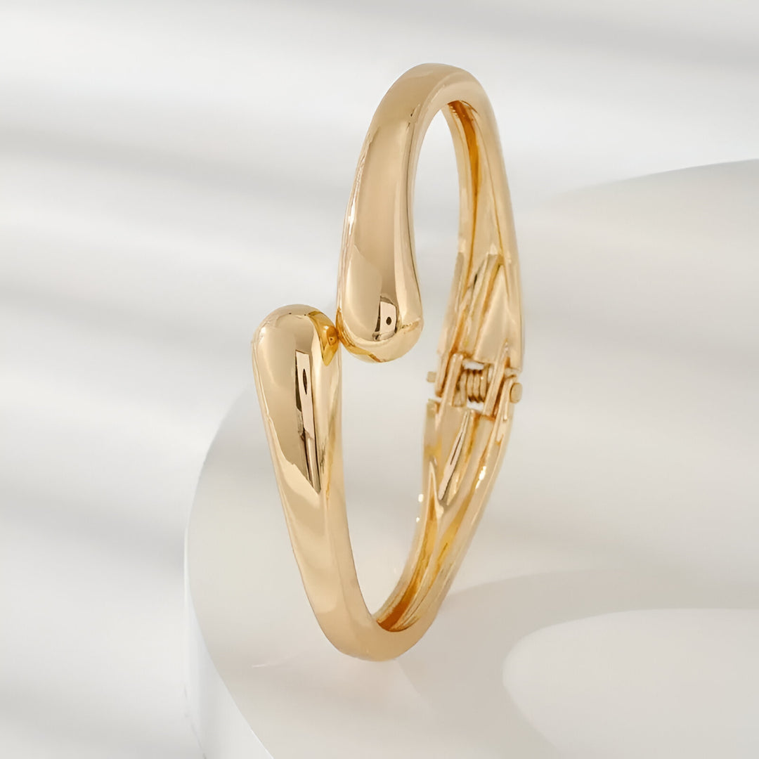 Bracelet courbe en zinc et plaqué or 14k debout vue latérale avec éclairage naturel - bracelet chic