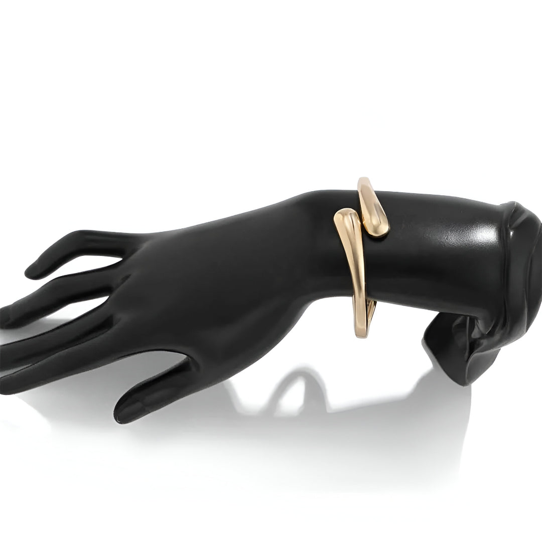 Main factice noir portant le Bracelet courbe enlacée en or 14 carats et alliage de zinc - sur fond blanc