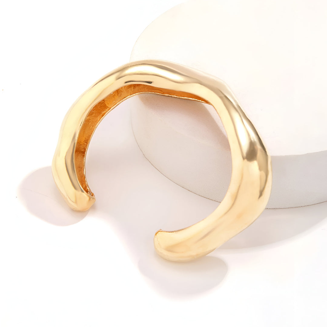 Bracelet Courbe Sculpté en zinc plaqué or 14K, détail du design incurvé avec ouverture apparente.
