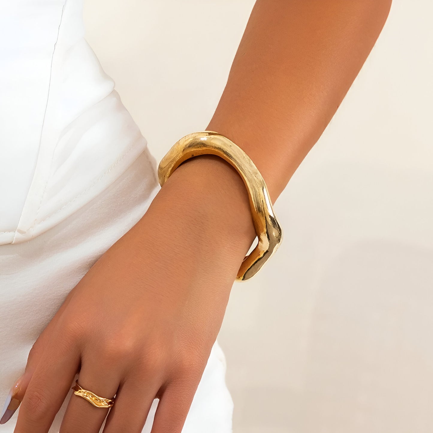 Bracelet Courbe Sculpté en alliage de zinc plaqué or 14K, porté au poignet, style moderne et élégant.