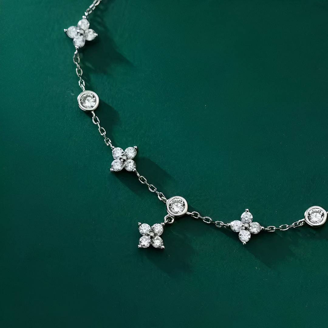 Bracelet Pluie de Lumière en Argent Sterling 925 et plaqué Or Blanc 18K, avec pierres de moissanite disposées en cercles argentés, sur fond vert foncé.