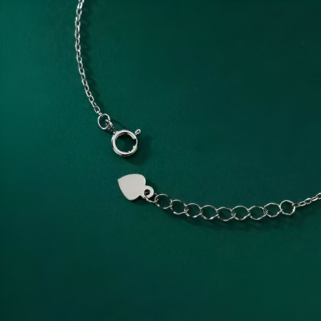 Bracelet Pluie de Lumière en Argent Sterling 925 et plaqué Or Blanc 18K, avec pierres de moissanite disposées en cercles argentés, vue du fermoir du bracelet sur fond vert foncé.