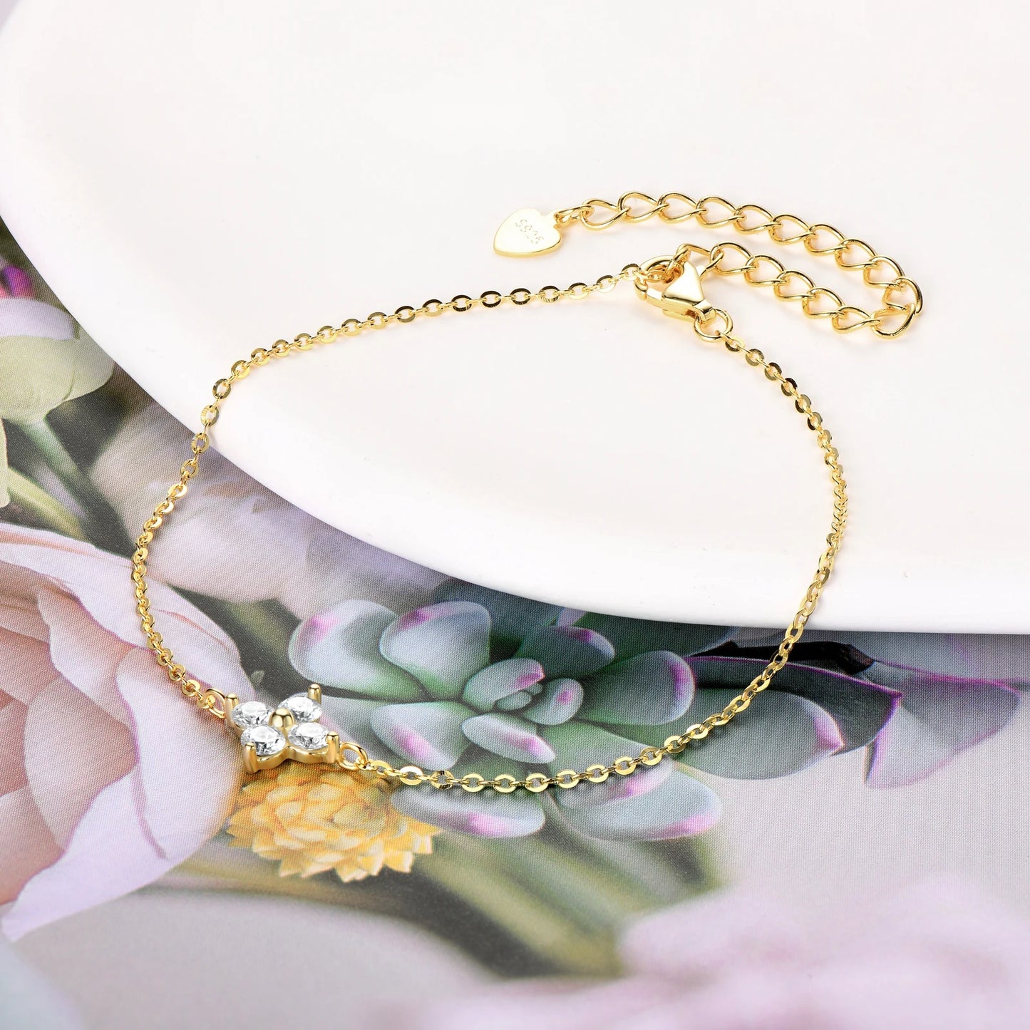 Bracelet fleur de luxe en or 18K posé sur un bord d’assiette, ajoutant une touche de luxe à votre table