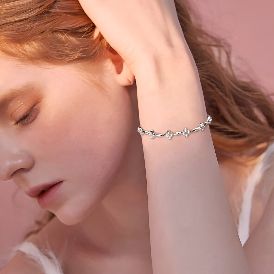 Bracelet fleur en or blanc et diamants synthétiques porté au poignet d'une femme vue de face.