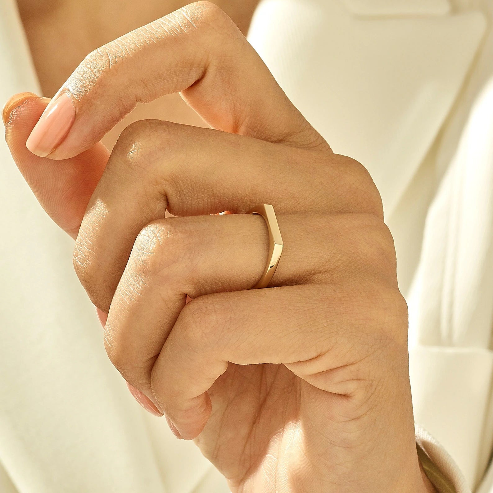 Bague chevalière pavé fin en acier plaqué or jaune portée au doigt 'une femme.