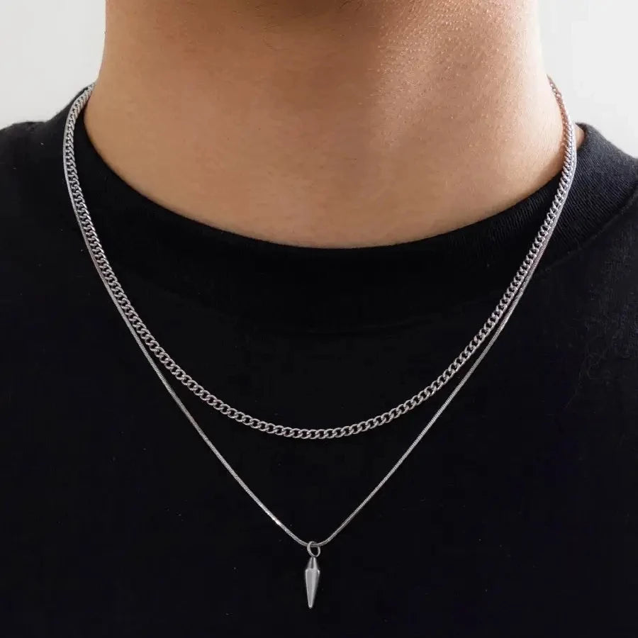 Collier double chaîne en acier inoxydable porté au cou d'un homme vue de proche.