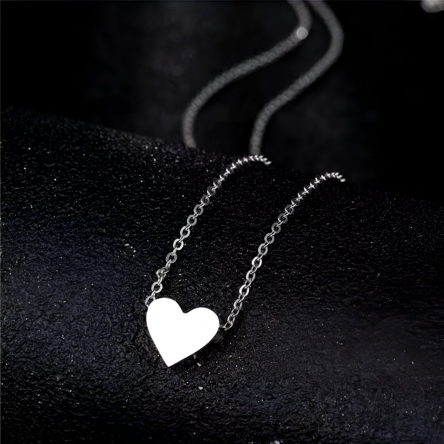 Collier fantaisie cœur en or blanc posé.