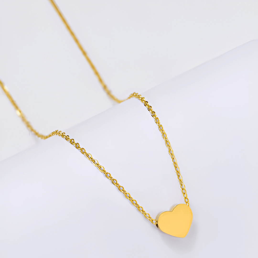 Collier fantaisie cœur en or jaune posé.