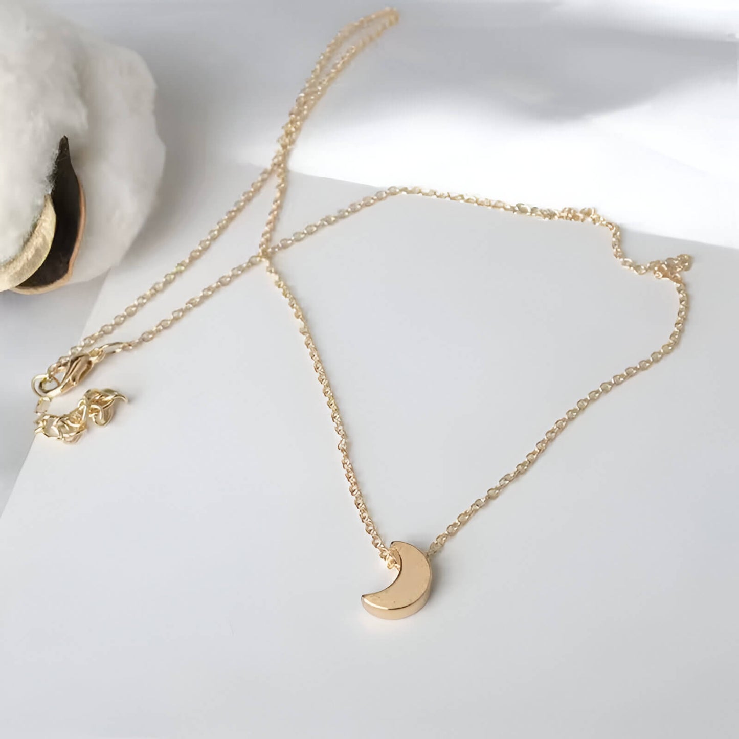 Collier fantaisie lune en or jaune à plat.