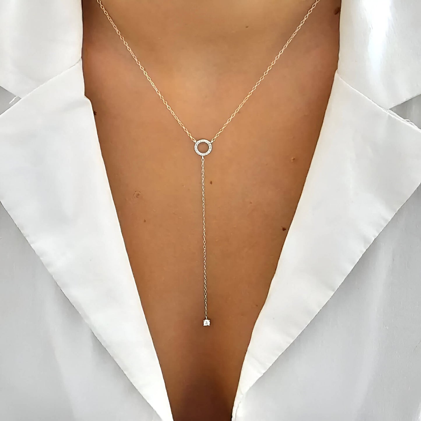 Collier lariat en or blanc et diamants naturels porté au cou d'une femme.