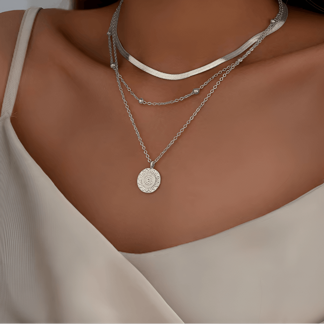 Collier multichaîne en or blanc porté au cou d'une femme.