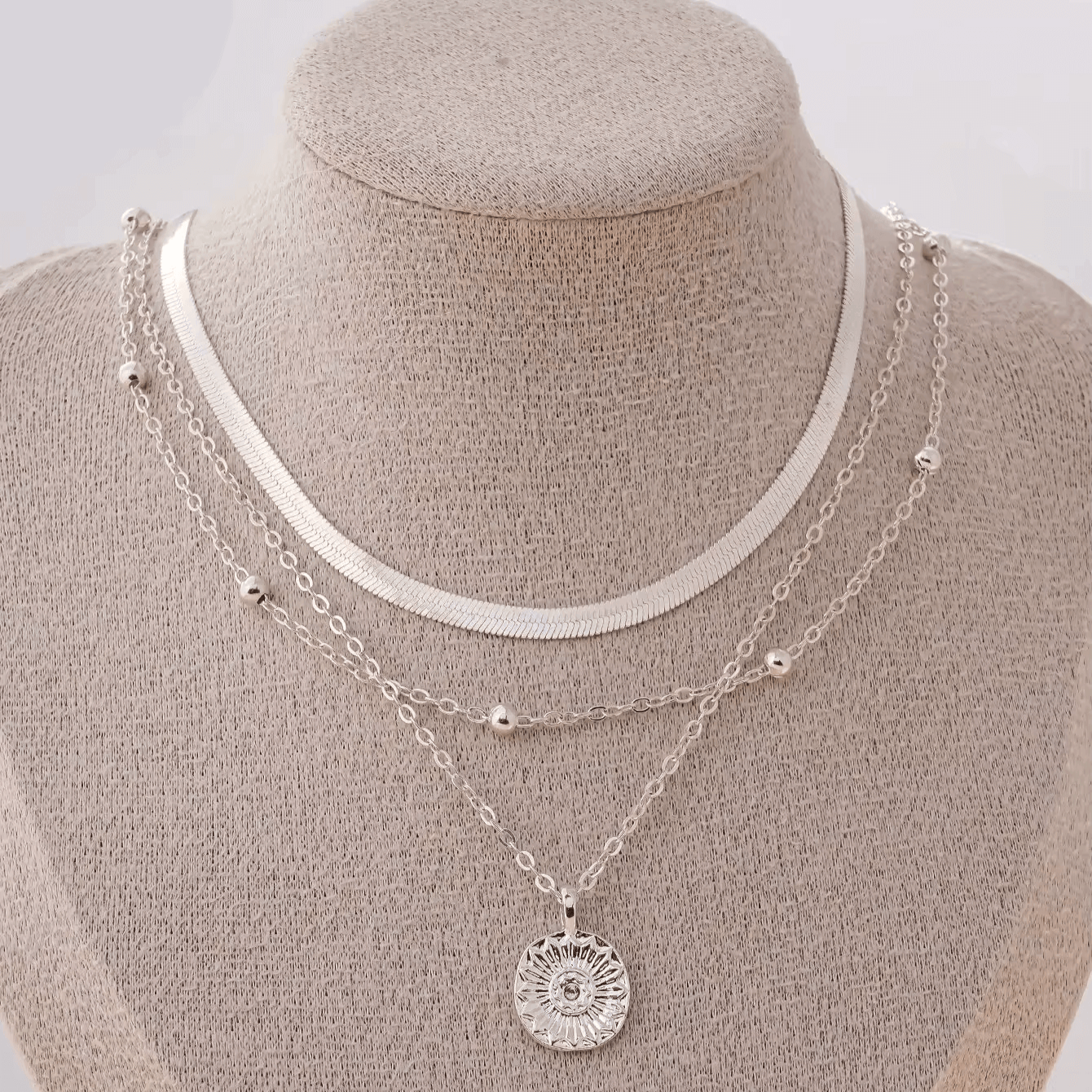 Collier multichaîne en or blanc porté sur un mannequin.