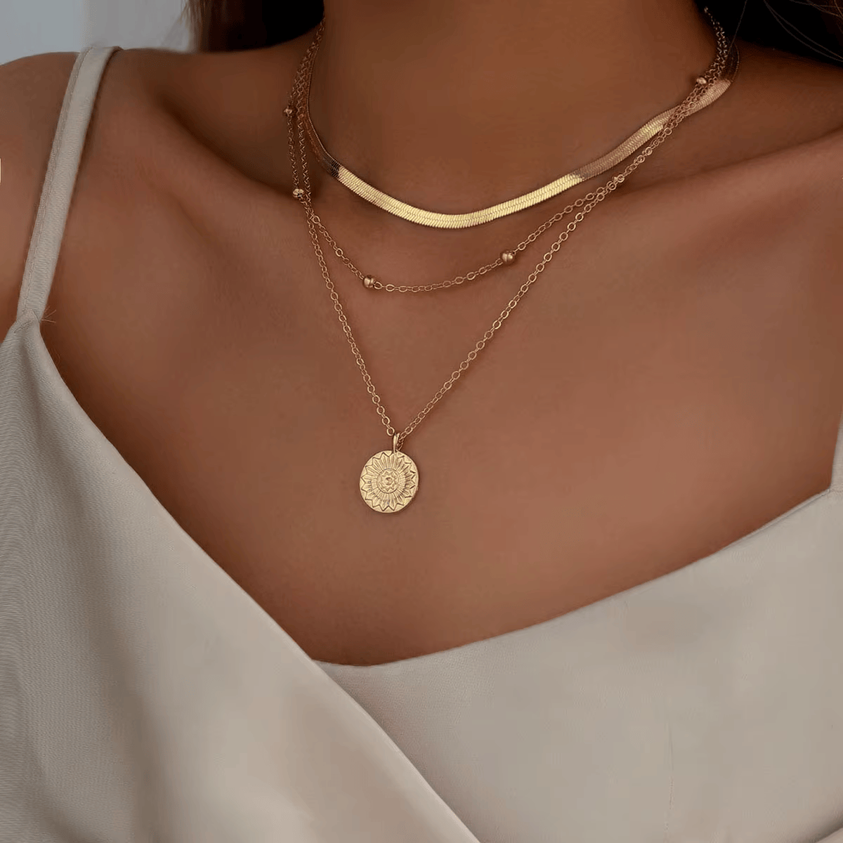 Collier multichaîne en or jaune porté au cou d'une femme.