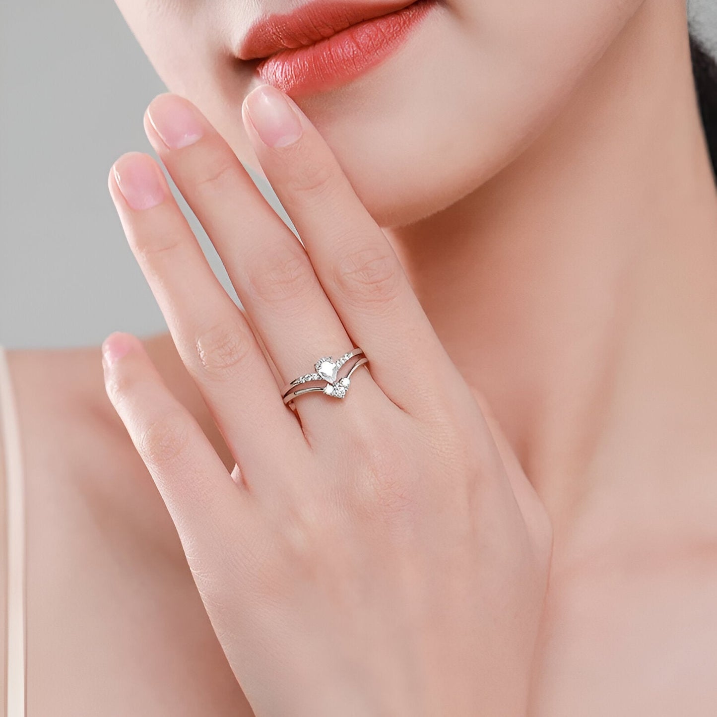 Double bague de fiançailles empilade Laurie en argent 925 rhodié et diamants étincelants portée au doigt d'une femme vue de proche.