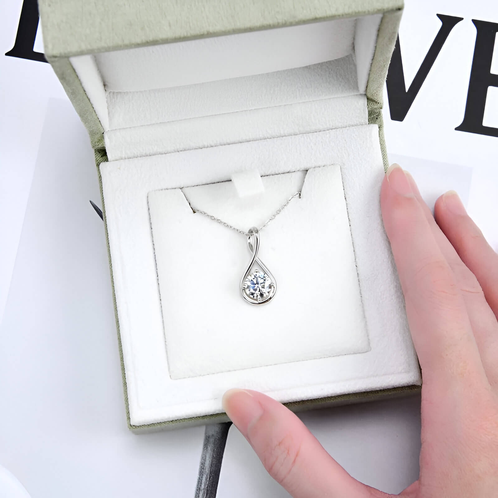 Pendentif goutte solitaire en or blanc et diamant synthétique dans son écrin.