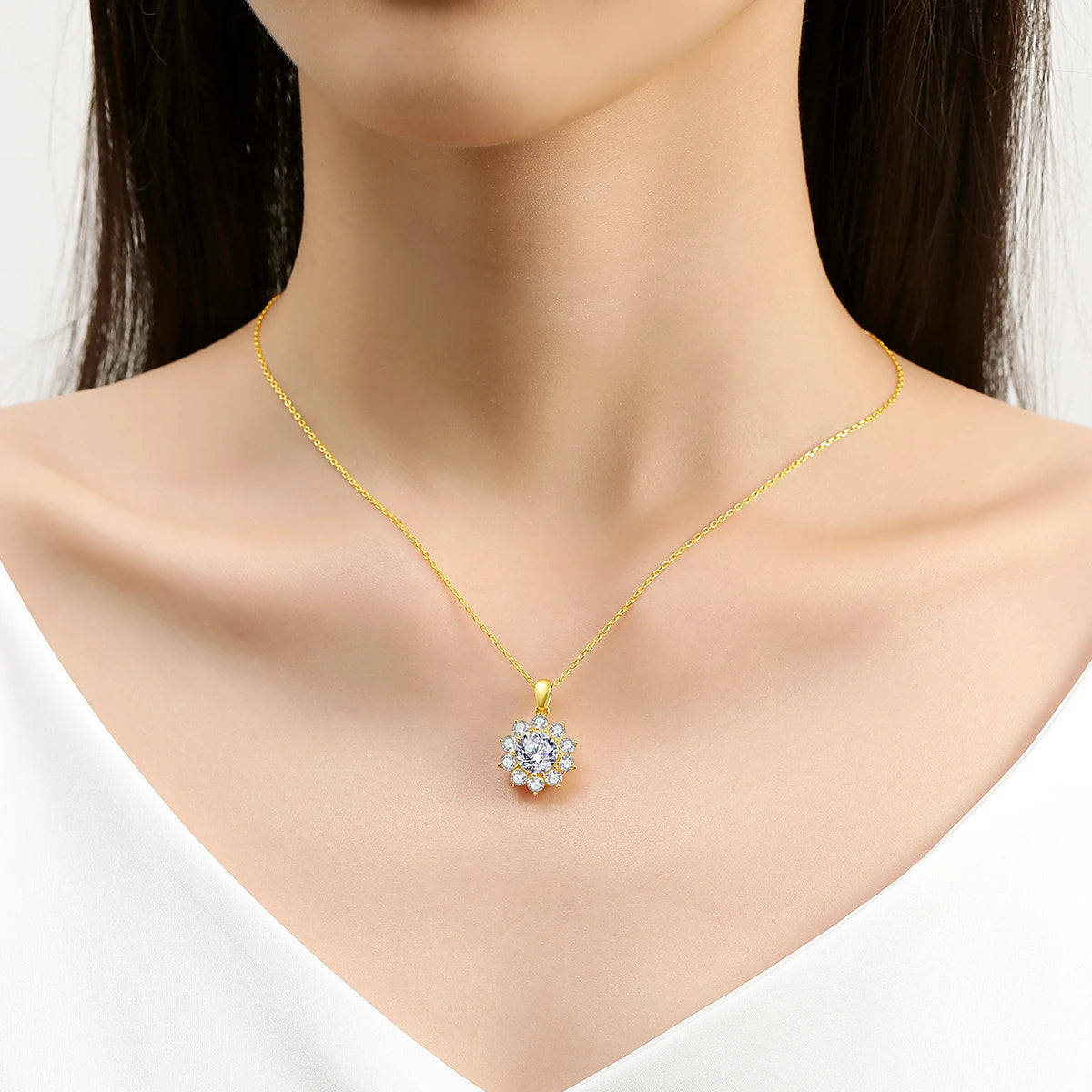 Pendentif médaillon solaire en or jaune serti d'un diamant synthétique et de diamants naturels porté au cou d'une femme.