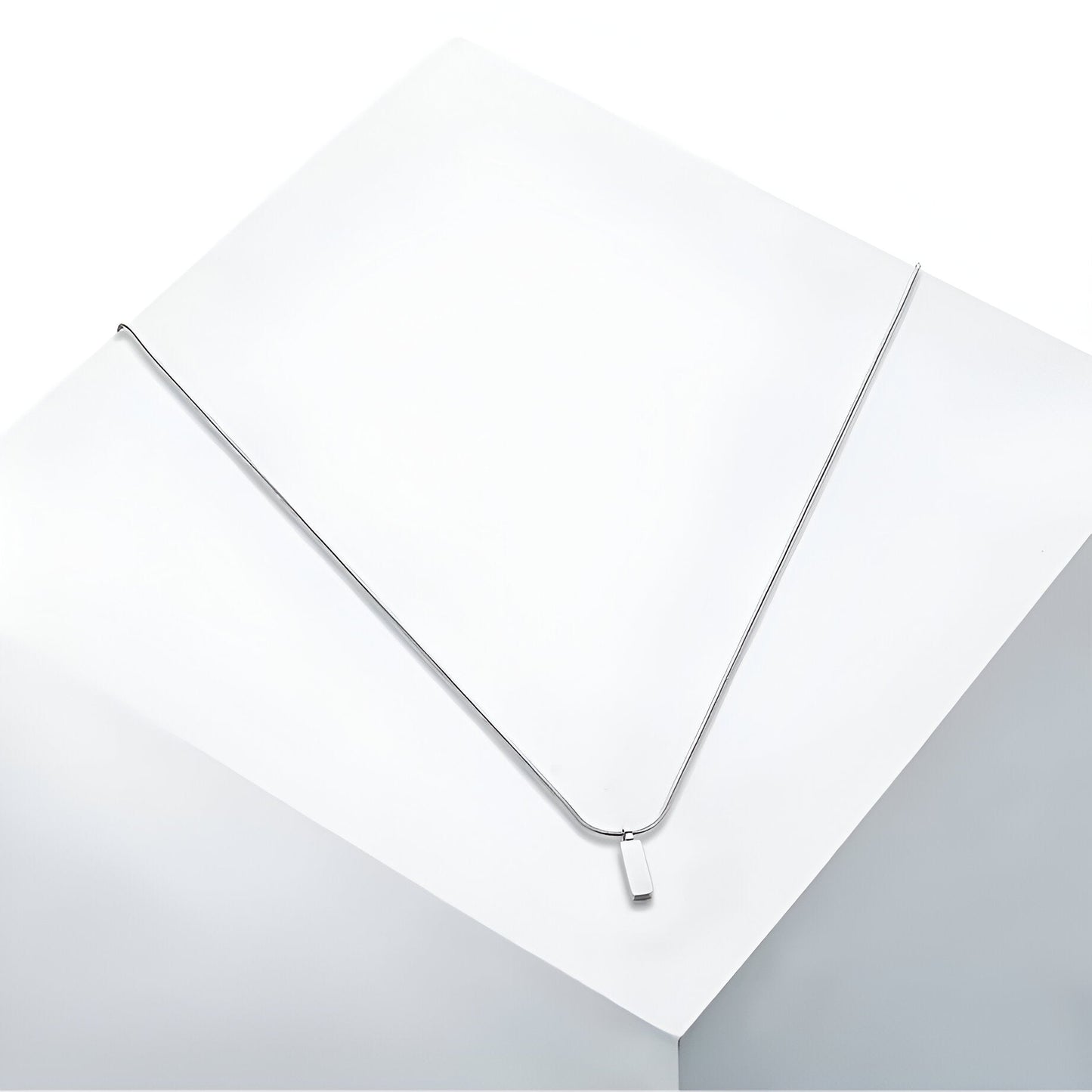 Pendentif rectangulaire en acier inoxydable et or blanc vue en gros plan.