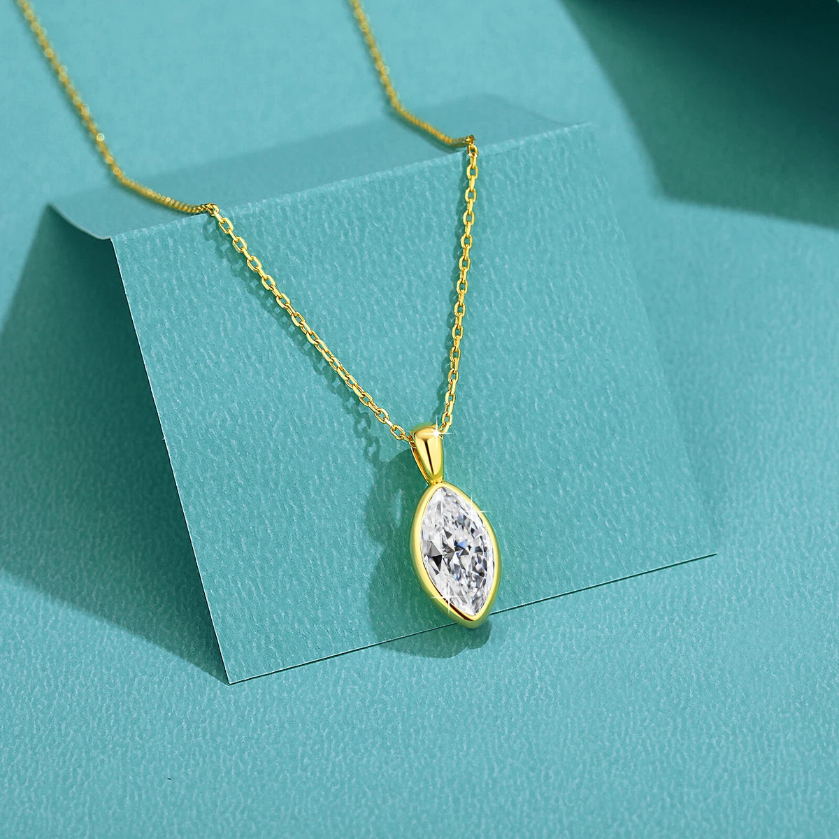 Pendentif solitaire navette en or jaune et diamant synthétique posé.