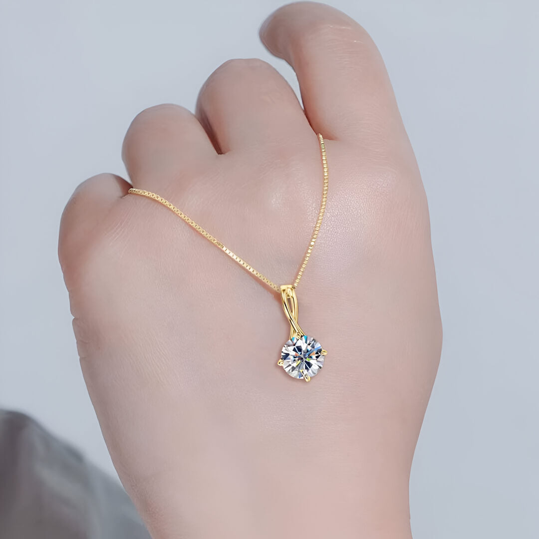 Pendentif solitaire en or jaune et diamant synthétique sur une main vue de face.