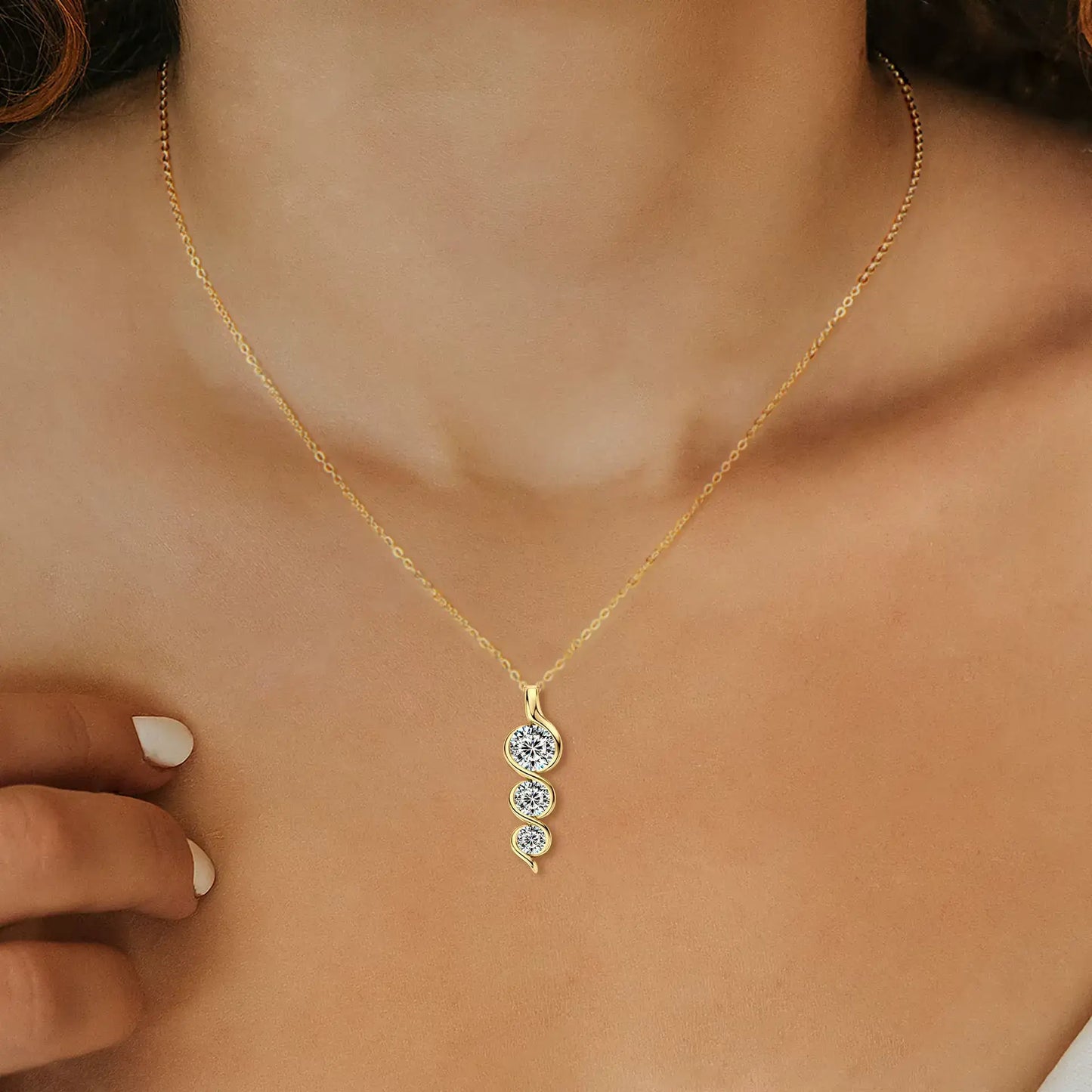 Pendentif torsadé en argent 925 plaqué or jaune et diamants scintillants porté au cou d'une femme vue de face.