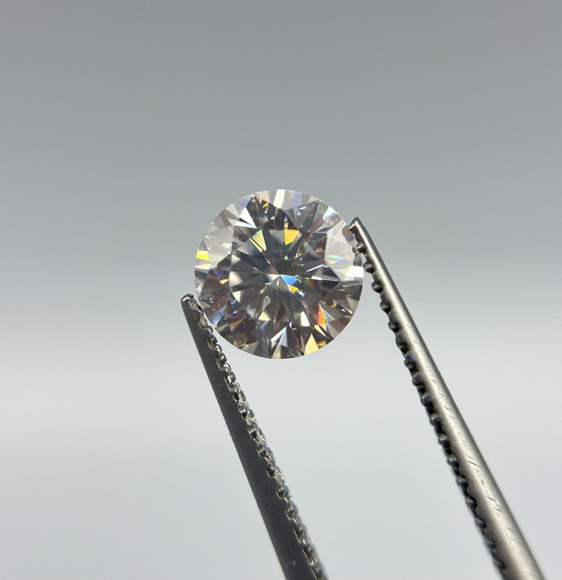 Diamants en moissanite brillants, capturés dans une pince de bijoutier, illustrant la beauté et la clarté exceptionnelles de cette pierre précieuse alternative au diamant. La moissanite, d'une dureté remarquable, offre un éclat incomparable à un prix plus accessible. Découvrez la moissanite, un choix élégant et durable pour vos bijoux. - La Petite Rebelle