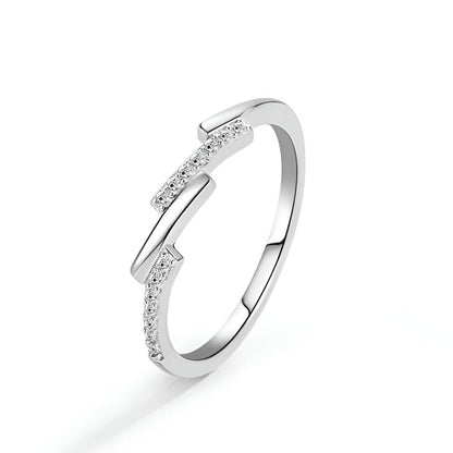 Alliance asymétrique en acier inoxydable et or blanc sertie d'oxydes de zirconium sur fond blanc.